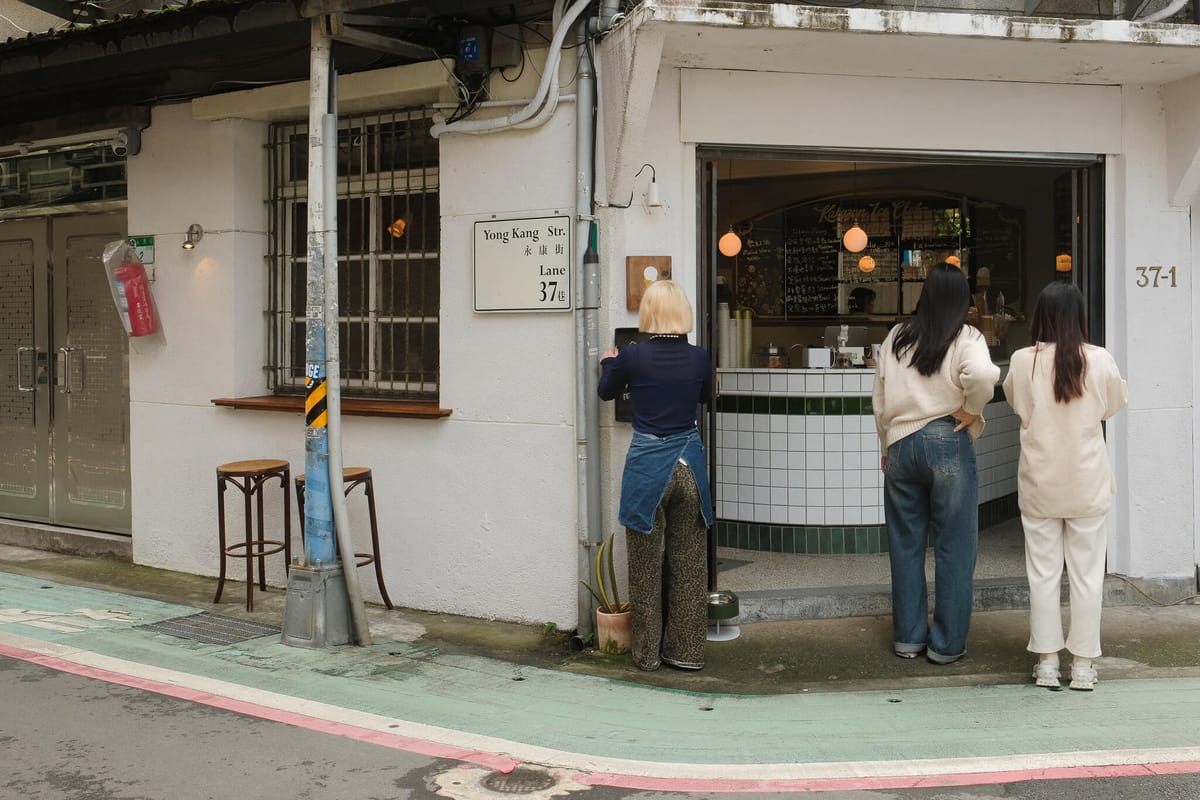 People gathered around a shopfront on the corner of Yong Kang Street, Taipei
